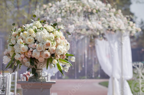 Fotografía Hermoso ramo de rosas en un jarrón sobre un fondo de un arco de la boda