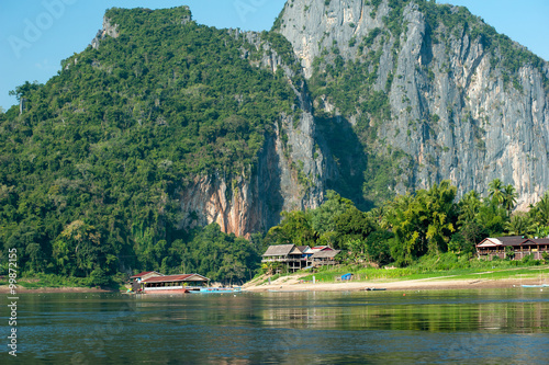 Foto Traditional village on foot of big mountain in Laos countryside