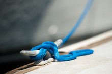 Blue Rope Tied To Metal Cleat On Boat Dock