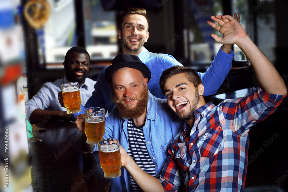 Young men drinking beer in pub