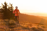 Fototapeta Góry - young happy women running in the cold morning with sunshine after sunrise