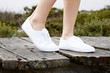 © sanneberg - White sneakers on model walking on boardwalk, close up