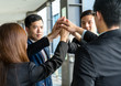 © leungchopan - Group of business people joining hand together and raised up