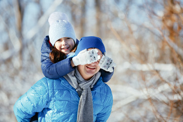 father and daughter playing in the snow in winter