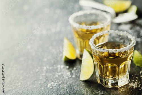 Fotografie, Obraz Tequila shot with lime and sea salt on black table, selective focus