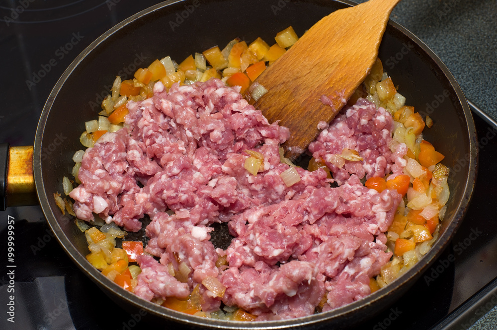 Raw minced meat with onions and peppers in a frying pan - obrazy, fototapety, plakaty 