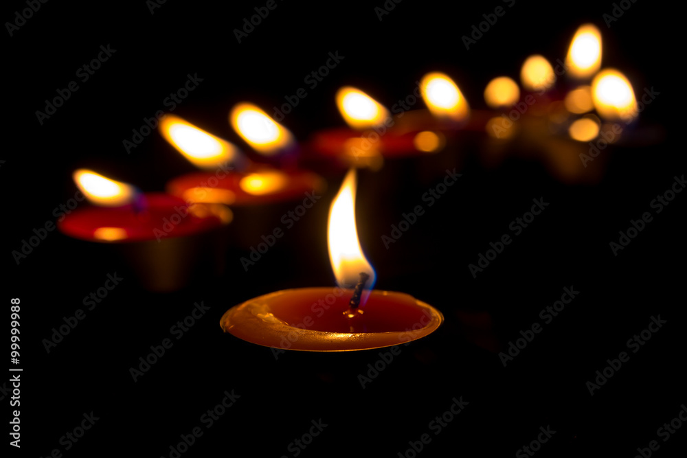 Burning candles on a dark background with warm light - obrazy, fototapety, plakaty 