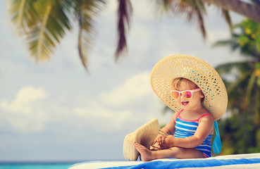 cute little girl in big hat on summer beach