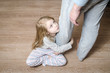 © izholudeva - Young girl hugging her father's leg