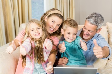 Wall Mural - Happy family using laptop with thumbs up