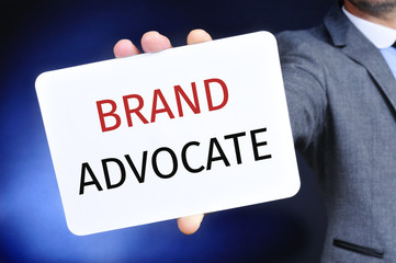 Wall Mural - businessman shows a signboard with the text brand advocate