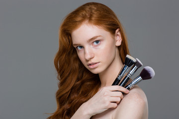 Canvas Print - Attractive young redhead woman holding set of makeup brushes