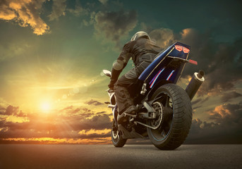 Man seat on the motorcycle under sky with clouds