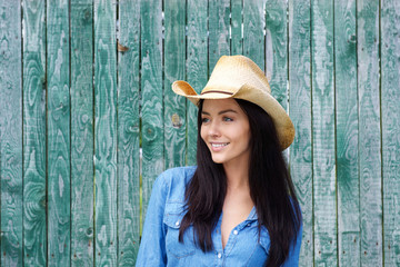 Wall Mural - Attractive young brunette woman smiling with cowboy hat