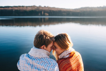 Happy young couple in love wearing warm clothes cuddling at a la