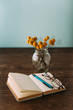 Notebook, flowers Craspedia, pen and glasses