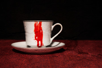 A vampire's tea cup with blood running down the side; textured image