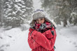 © Laszlo - Outdoor portrait of young woman, looking at the camera. Snow covered pine trees on the background. Arms crossed.