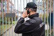 © Andrey Popov - Security Guard Talking On Mobile Phone In Front Of Gate