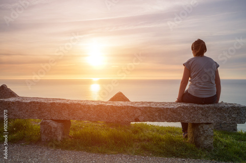 Fotografie, Obraz Chica joven observando el atardecer sobre el mar en soleda