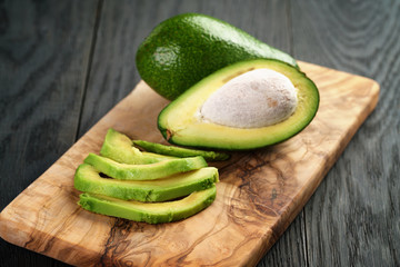 Wall Mural - sliced ripe avocados on olive cutting board