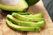 Sliced Ripe Avocados On Olive Cutting Board