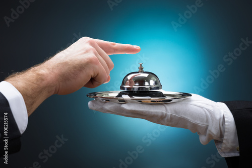 Fotografie, Obraz Businessman Ringing In Service Bell Held By Bellboy
