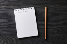 Shopping List Phrase In Notepad On Gray Wood Table