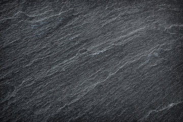 dark grey / black slate background or texture.