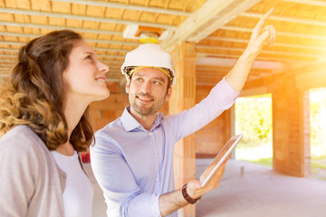 Young woman and architect on construction site