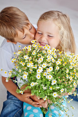 Wall Mural - Happy kids with camomile bouquet at home