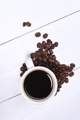 Wall Mural - Cup of coffee with coffee beans on wooden background