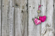 Key and hearts hanging on rustic wood door