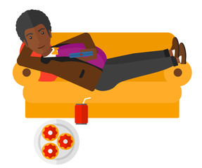 Wall Mural - Man lying on sofa with junk food.