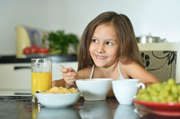 Wall Mural - Beautiful little girl with breakfast