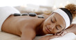 © Dash - Beautiful ethnic client being treated with hot stone therapy at a luxury health spa