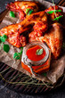 Chicken wings with hot tomato sauce on a chopping board