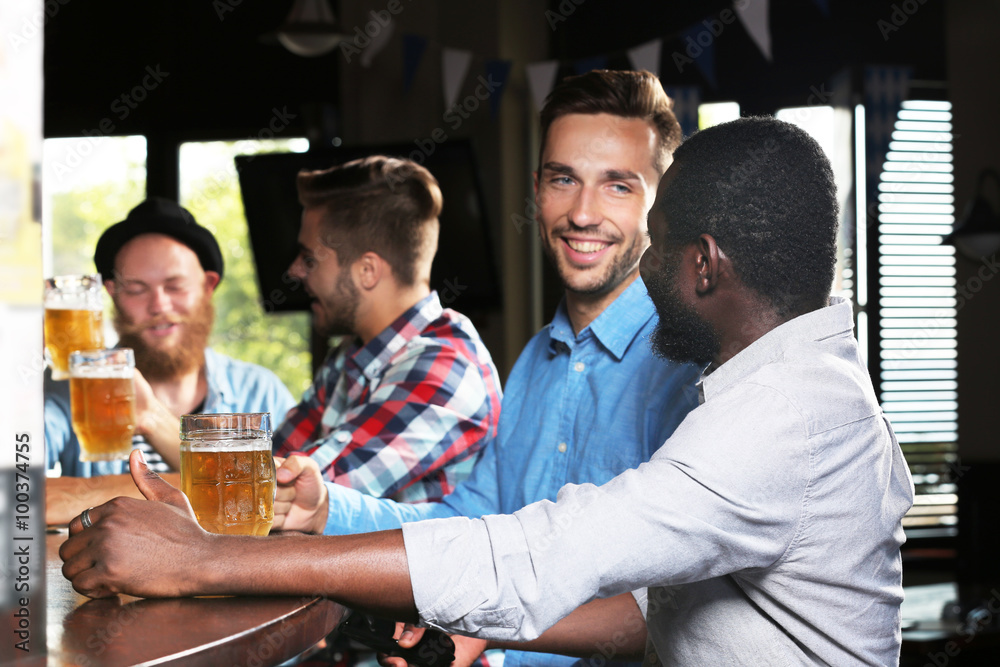 Young men drinking beer in pub