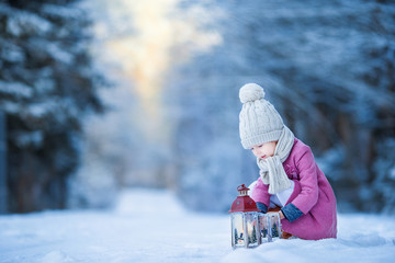 Wall Mural - Adorable little girl with flashlight in frozen winter on Christmas outdoors