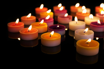 Wall Mural - Many burning small candles on dark background