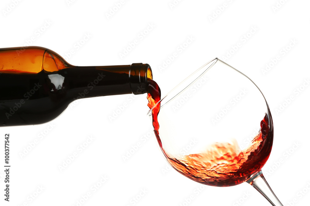 Red wine pouring in glass, isolated on white