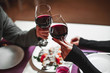 Two people toasting with wine glasses. young couple drinking red wine at bar
