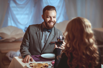 Wall Mural - Beautiful young couple with glasses of red wine in luxury restaurant