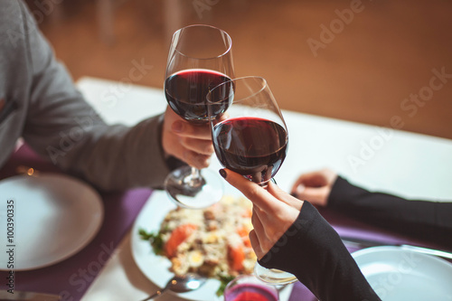 Fotografía Beautiful young couple with glasses of red wine in luxury restaurant