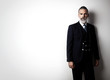 © SFIO CRACHO - Portrait of bearded gentleman wearing trendy suit and stands against the empty white wall.