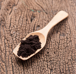 Sticker - close up of a spoon and black powder on wood