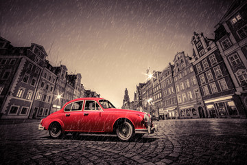 Fototapete - Retro red car on cobblestone historic old town in rain. Wroclaw, Poland.