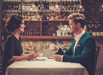 Wall Mural - Stylish wealthy couple having desert and coffee together in a restaurant.