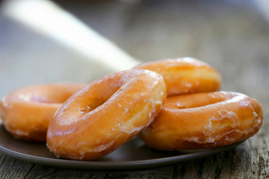 Fresh glazed donuts background image served on a plate