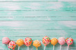 Cake pops on turquoise  painted wooden background.
